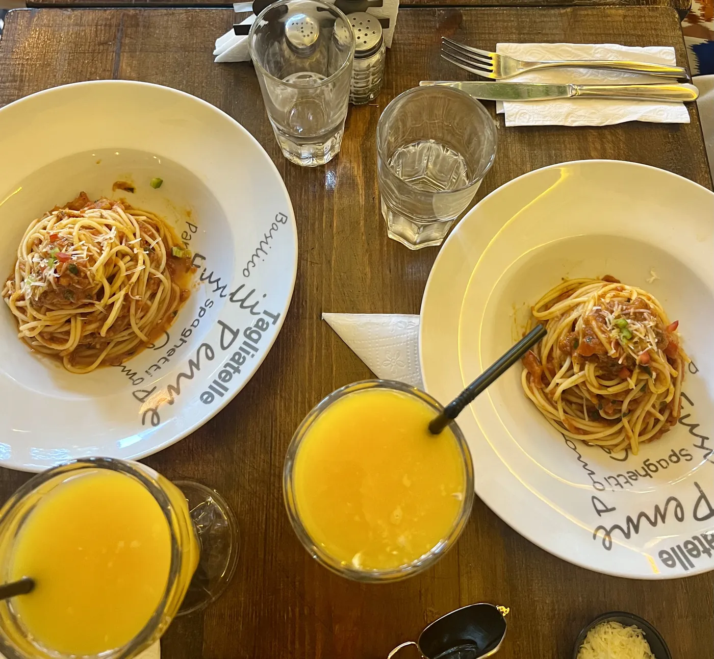 Two plates of spaghetti bolognese with orange juice at Culture Box