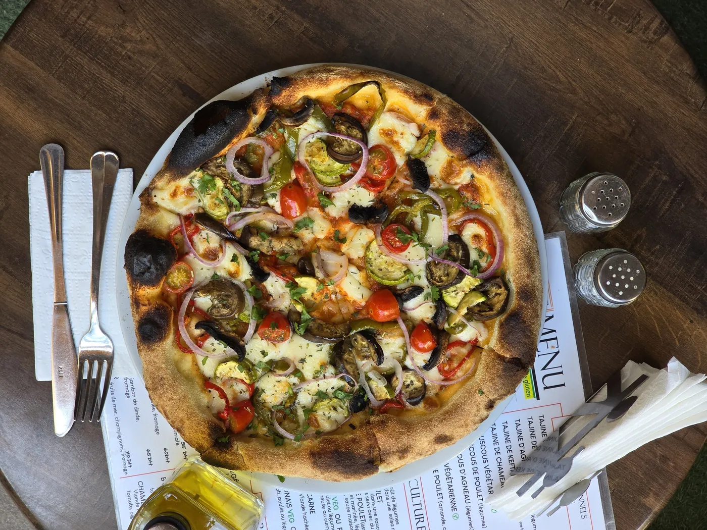 Homemade pizza with fresh tomatoes and greens at Culture Box
