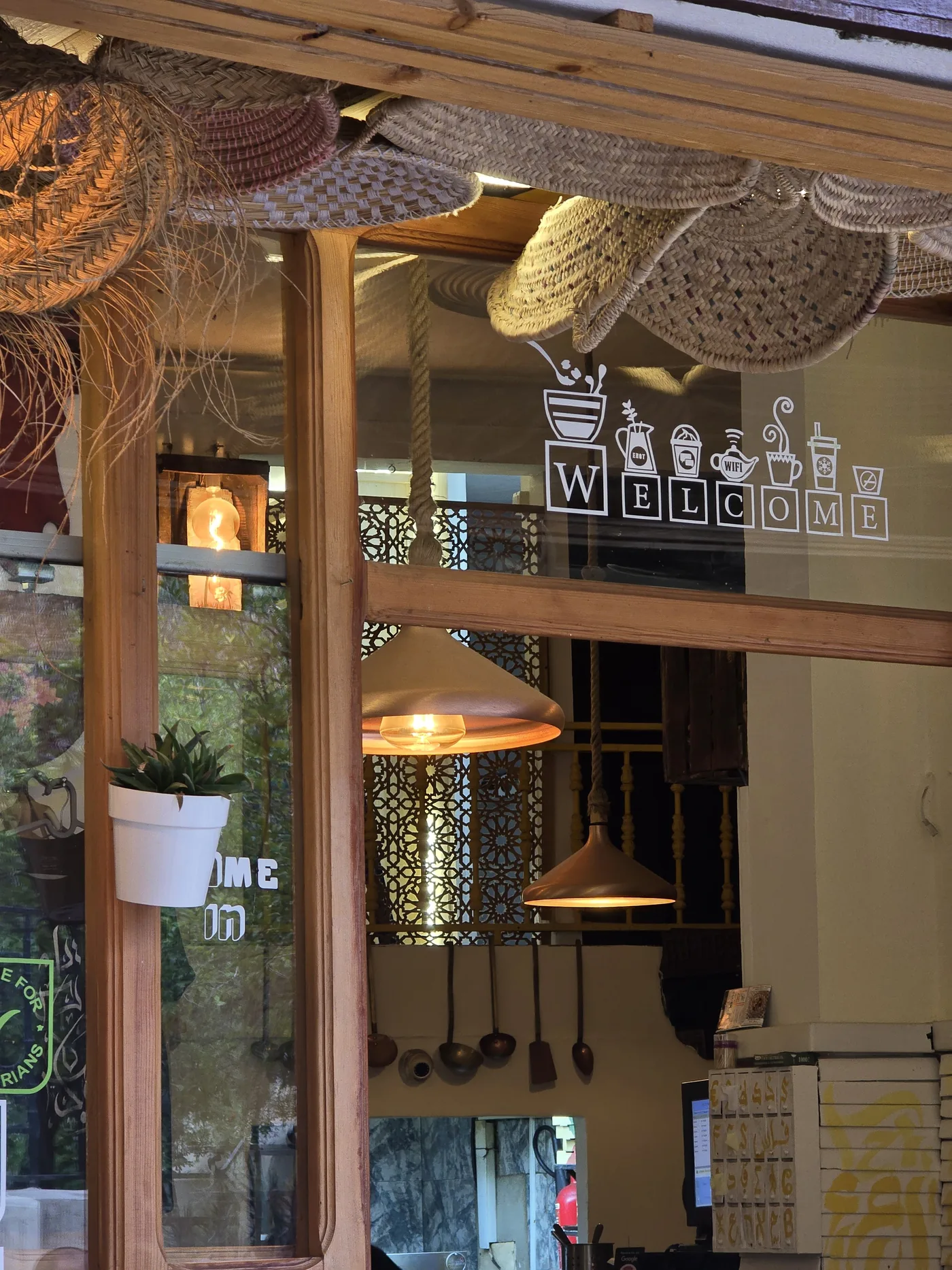 The WELCOME glass door of Culture Box with pendant lights and plants